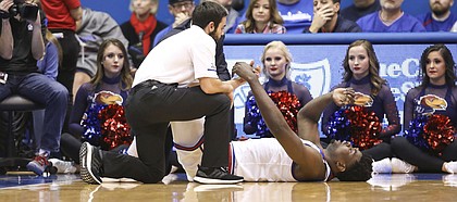 Kansas center Udoka Azubuike (35) lies on the ground with an injury as trainers come in to assist during the first half on Tuesday, Dec. 4, 2018 at Allen Fieldhouse.