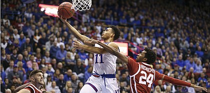 Kansas guard Devon Dotson (11) cruises in for a bucket past Oklahoma guard Jamal Bieniemy (24) during the first half, Wednesday, Jan. 2, 2019 at Allen Fieldhouse.