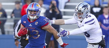 Kansas kickoff returner Ryan Schadler (33) escapes special teams players Colby Moore (19) and Matthew McCrane during the fourth quarter on Saturday, Oct. 28, 2017 at Memorial Stadium.