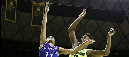 Kansas guard Devon Dotson (11) scores over Baylor forward Flo Thamba (0) in the first half of an NCAA college basketball game, Saturday, Jan. 12, 2019, in Waco, Texas.