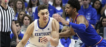 Kentucky's Reid Travis (22) drives on Kansas' Dedric Lawson during the second half of an NCAA college basketball game in Lexington, Ky., Saturday, Jan. 26, 2019. Kentucky won 71-63. (AP Photo/James Crisp)