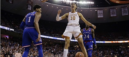 Texas forward Jaxson Hayes (10) celebrates after he scored between Kansas forward Dedric Lawson (1) and guard Lagerald Vick (24) during the second half on an NCAA college basketball game in Austin, Texas, Tuesday, Jan. 29, 2019. Texas won 73-63. (AP Photo/Eric Gay)