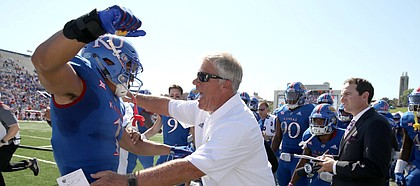 Kansas safety Bryce Torneden (1) gets a hug from defensive analyst Dirk Wedd, who recently retired as long time Lawrence High head coach, after Torneden's interception and touchdown during the first quarter on Saturday, Sept. 15, 2018 at Memorial Stadium.