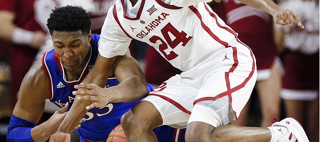 Kansas forward David McCormack (33) and Oklahoma guard Jamal Bieniemy (24) fight for the ball in the first half of an NCAA college basketball game in Norman, Okla., Tuesday, March 5, 2019. (AP Photo/Nate Billings)
