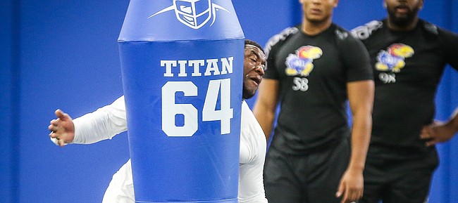 Former Kansas defensive end Daniel Wise prepares to throw a practice dummy as he works out for NFL representatives during Pro Day on Wednesday, March 27, 2019 at the Kansas Football Indoor Practice Facility.