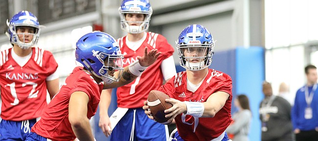 Kansas quarterback Carter Stanley fakes a handoff during football practice on Wednesday, March 6, 2019 within the new indoor practice facility.