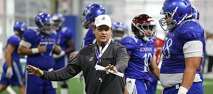 Kansas head coach Les Miles works with offensive lineman Api Mane on Thursday, April 4, 2019 at the indoor practice facility.