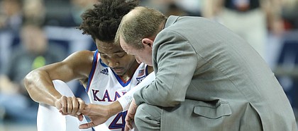 Kansas guard Devonte' Graham (4) sits on the floor with trainer Bill Cowgill after suffering an injury during the first half, Saturday, March 17, 2018 in Wichita, Kan.