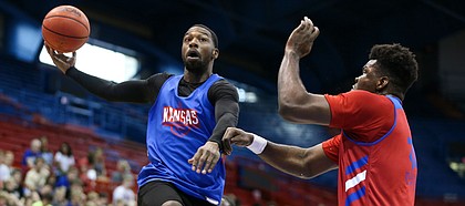 Former Kansas guard Elijah Johnson tosses an over-the-shoulder pass while defended by Kansas center Udoka Azubuike during a scrimmage on Tuesday, June 11, 2019 at Allen Fieldhouse.