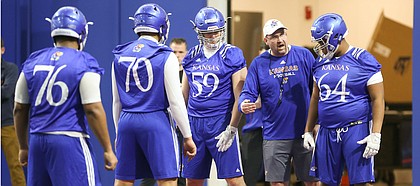 Kansas offensive line coach Luke Meadows gives instruction to lineman Jalan Robinson (54) during football practice on Wednesday, March 6, 2019 within the new indoor practice facility.
