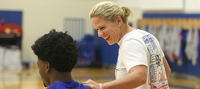 Trainer Andrea Hudy jokes with freshman Josh Jackson as the players get stretched out prior to the start of Boot Camp in the practice gym on Friday, Sept. 23, 2016 just after 6 a.m.
