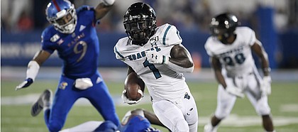Coastal Carolina's CJ Marable gets past two Kansas defenders Saturday night at David Booth Kansas Memorial Stadium on Sept. 7, 2019.