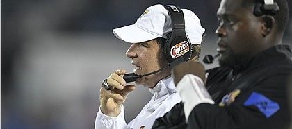 Kansas head coach Les Miles talks on the radio to assistants Saturday against Coastal Carolina Saturday night at David Booth Kansas Memorial Stadium on Sept. 7, 2019.