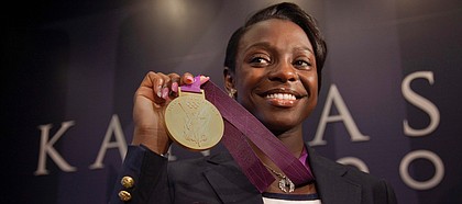 In this Journal-World file photo from Aug. 15, 2012, then-University of Kansas track star and Olympic athlete Diamond Dixon holds her gold medal during a press conference.