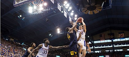 Kansas guard Christian Braun (2) goes hard for a bucket and a foul against West Virginia forward Oscar Tshiebwe (34) during the second half, Saturday, Jan. 4, 2020 at Allen Fieldhouse.