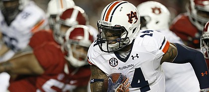 Auburn quarterback Nick Marshall (14) runs against Alabama during the first half of the Iron Bowl NCAA college football game, Saturday, Nov. 29, 2014, in Tuscaloosa, Ala. (AP Photo/Butch Dill)