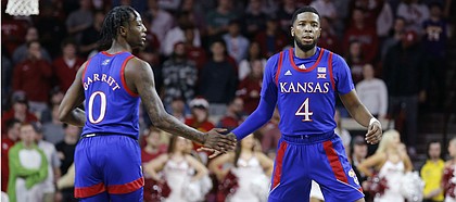 Kansas' Marcus Garrett (0) and Isaiah Moss (4) slap hands during the first half of the team's NCAA college basketball game against Oklahoma in Norman, Okla., Tuesday, Jan. 14, 2020.