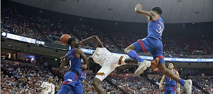 Texas guard Andrew Jones (1) is fouled by Kansas guard Marcus Garrett (0) as he tries to score during the second half of an NCAA college basketball game, Saturday, Jan. 18, 2020, in Austin, Texas. (AP Photo/Eric Gay)