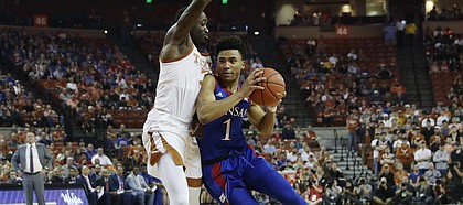 Kansas guard Devon Dotson (1) drives around Texas guard Courtney Ramey (3) during the first half of an NCAA college basketball game, Saturday, Jan. 18, 2020, in Austin, Texas. (AP Photo/Eric Gay)