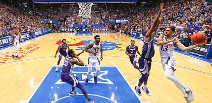Kansas guard Tristan Enaruna (13) sweeps around to throw a pass during the second half, Tuesday, Jan. 21, 2020 at Allen Fieldhouse.