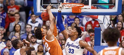 Kansas forward David McCormack (33) get his hand caught in the net after stuffing a shot by Texas forward Kai Jones during the first half on Monday, Feb. 3, 2020 at Allen Fieldhouse.