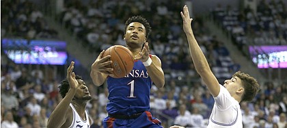 Kansas guard Devon Dotson (1) handles the ball inside a TCU center Kevin Samuel (21) and guard Francisco Farabello (3) defend during the first half of an NCAA college basketball game, Saturday, Feb. 8, 2020, in Fort Worth, Texas. (AP Photo/Ron Jenkins)