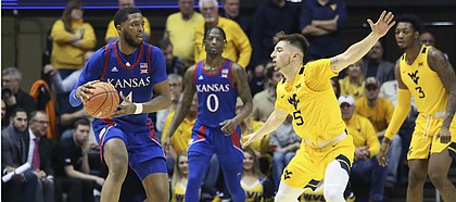 Kansas guard Isaiah Moss (4) is defended by West Virginia guard Jordan McCabe (5) as Kansas guard Marcus Garrett watches during the second half of an NCAA college basketball game Wednesday, Feb. 12, 2020, in Morgantown, W.Va. (AP Photo/Kathleen Batten)