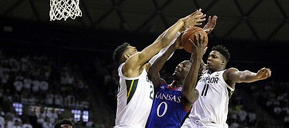 Baylor forward Tristan Clark, left, and Baylor guard Mark Vital, right, defend Kansas guard Marcus Garrett, center, under the basket during the first half of an NCAA college basketball game on Saturday, Feb. 22, 2020, in Waco, Texas. (AP Photo/Ray Carlin)