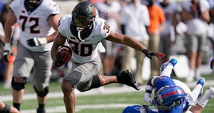Oklahoma State running back Chuba Hubbard (30) breaks away from Kansas cornerback Johnquai Lewis (11) during the first half of an NCAA college football game in Lawrence, Kan., Saturday, Oct. 3, 2020.