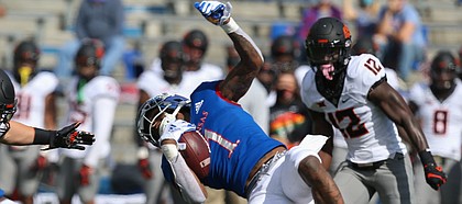 KU junior Pooka Williams Jr. is taken down by the Oklahoma State defense during KU's 47-7 loss to the Cowboys on Saturday, Oct. 3, 2020 at David Booth Kansas Memorial Stadium.