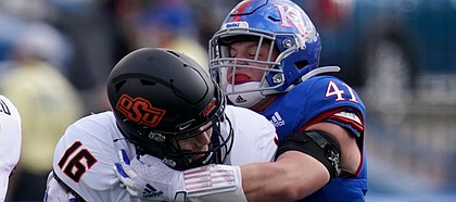 Oklahoma State quarterback Shane Illingworth (16) is sacked by Kansas safety Nick Channel (41) during the first half of an NCAA college football game in Lawrence, Kan., Saturday, Oct. 3, 2020. (AP Photo/Orlin Wagner)