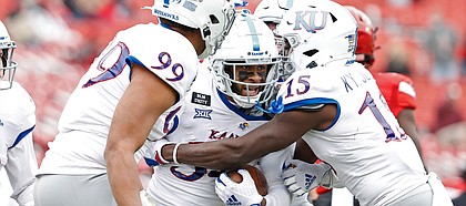 Kansas players celebrate with Nate Betts (34) after he recovered a fumble from Texas Tech during the second half of an NCAA college football game Saturday, Dec. 5, 2020, in Lubbock, Texas. (AP Photo/Brad Tollefson)