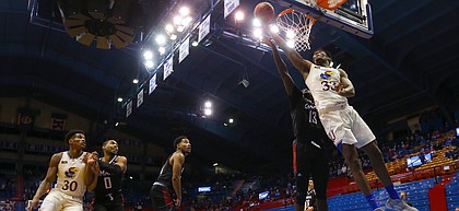 Kansas forward David McCormack (33) gets inside for a shot off the backboard past Omaha forward Wanjang Tut (13) during the second half on Friday, Dec. 11, 2020 at Allen Fieldhouse.