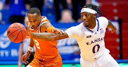 Kansas guard Marcus Garrett (0) and Texas guard Matt Coleman III (2) compete for a loose ball during the second half, Saturday, Jan. 2, 2021 at Allen Fieldhouse.