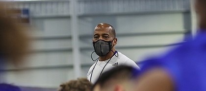 Kansas football interim head coach Emmett Jones speaks to the Jayhawks as they take a knee during the team's first spring practice, on March 30, 2021.