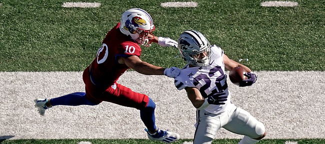 Kansas State running back Deuce Vaughn (22) is tackled by Kansas safety Jayson Gilliom (10) during the first half of an NCAA football basketball game against Kansas Saturday, Nov. 6, 2021, in Lawrence, Kan. (AP Photo/Charlie Riedel)
