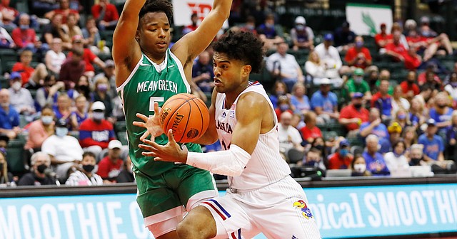 Kansas guard Remy Martin, right, drives to the basket in front of North Texas guard Tylor Perry during the second half of an NCAA college basketball game Thursday, Nov. 25, 2021, in Orlando, Fla. 
