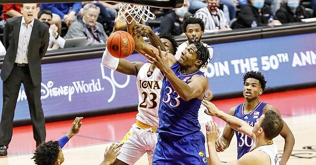 Kansas forward David McCormack (33) fights with Iona forward Nelly Junior Joseph (23) for a rebound during the second half of an NCAA college basketball game Sunday, Nov. 28, 2021, in Lake Buena Vista, Fla. (AP Photo/Jacob M. Langston)
