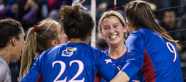 Kansas volleyball players, including outside hitter Caroline Bien (smiling), celebrate after a point during the Jayhawks' NCAA Tournament win over Oregon,  on Dec. 2, 2021, in Omaha, Neb.