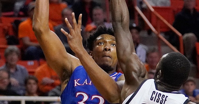Kansas forward David McCormack (33) shoots as Oklahoma State forward Moussa Cisse, right, defends, in the second half of an NCAA college basketball game Tuesday, Jan. 4, 2022, in Stillwater, Okla. (AP Photo/Sue Ogrocki)