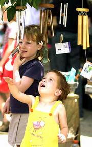 Wind chimes at Natural Way, 820 Mass., caught the attention of
Hannah Gerace, 3, and her big sister Allie, 6, of Lawrence.
