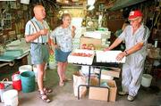 Tib and Pat Price, left and center, of DeSoto sample some of the
fresh peaches sold by Floyd Ott, right. Ott sells the fruit at his
home, at the Lawrence Farmers Market and at the Community
Mercantile Co-op.