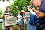 Mary Gage, Lawrence, left, displays a late 1800's photograph to
tourists Monday as they visited her in-laws' property south of
Kansas Highway 10 where the Blue Jacket crossing on the Wakarusa
River is located. Participants in the 18th Annual Oregon-California
Trails Assn. convention this week came to Douglas County to see the
spot where wagons passed through the area en route from
Independence, Mo., to Oregon.