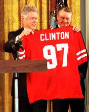 President Clinton, left, and former Nebraska football coach Tom
Osborne show off Cornhuskers football jersey during a ceremony
honoring NU as the NCAA college football co-champions in 1997.