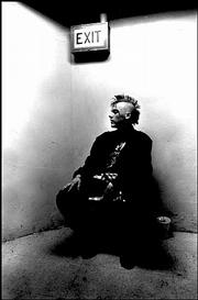 This person sits under an exit sign in Kansas City, Kan. The photo
can be found in Gary Smith&squot;s "Searching for Washington Square."