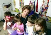 Students in the arts-based preschool at the Lawrence Arts Center
show their paint-covered hands to director Ann Evans. The
preschoolers are, from left, Nick Larkin, Joey Larkin, Bertie
Glicksman and Rachael Halpert. Lindsey Griffin is painting in the
background.