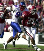 KU's Algie Atkinson, left, tries to catch Oklahoma's Quentin
Griffin. The Sooners prevailed, 34-16, Saturday in Norman, Okla.