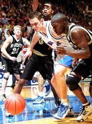 KU Center Eric Chenowith pushes past Emporia's T.J. Brown, right,
as he goes for the ball. Chenowith scored 10 points and added six
rebounds in the Jayhawks' 120-51 victory Saturday night in Allen
Fieldhouse.