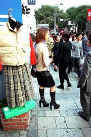 Resplendent in her 8-inch heels and leather skirt, a young shopper
pauses to chat on a Tokyo street corner.