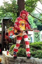 A young guitar player draws a crowd outside a subway stop in
Tokyo's trendy shopping district in Shibuya.